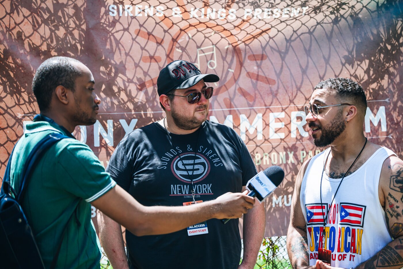 Mike Nickerson of Sounds & Sirens being interviewed in front of a 'Sirens & Kings Present: Bronx Summer Jam' backdrop, alongside Fernando Michael of The Fox & King.