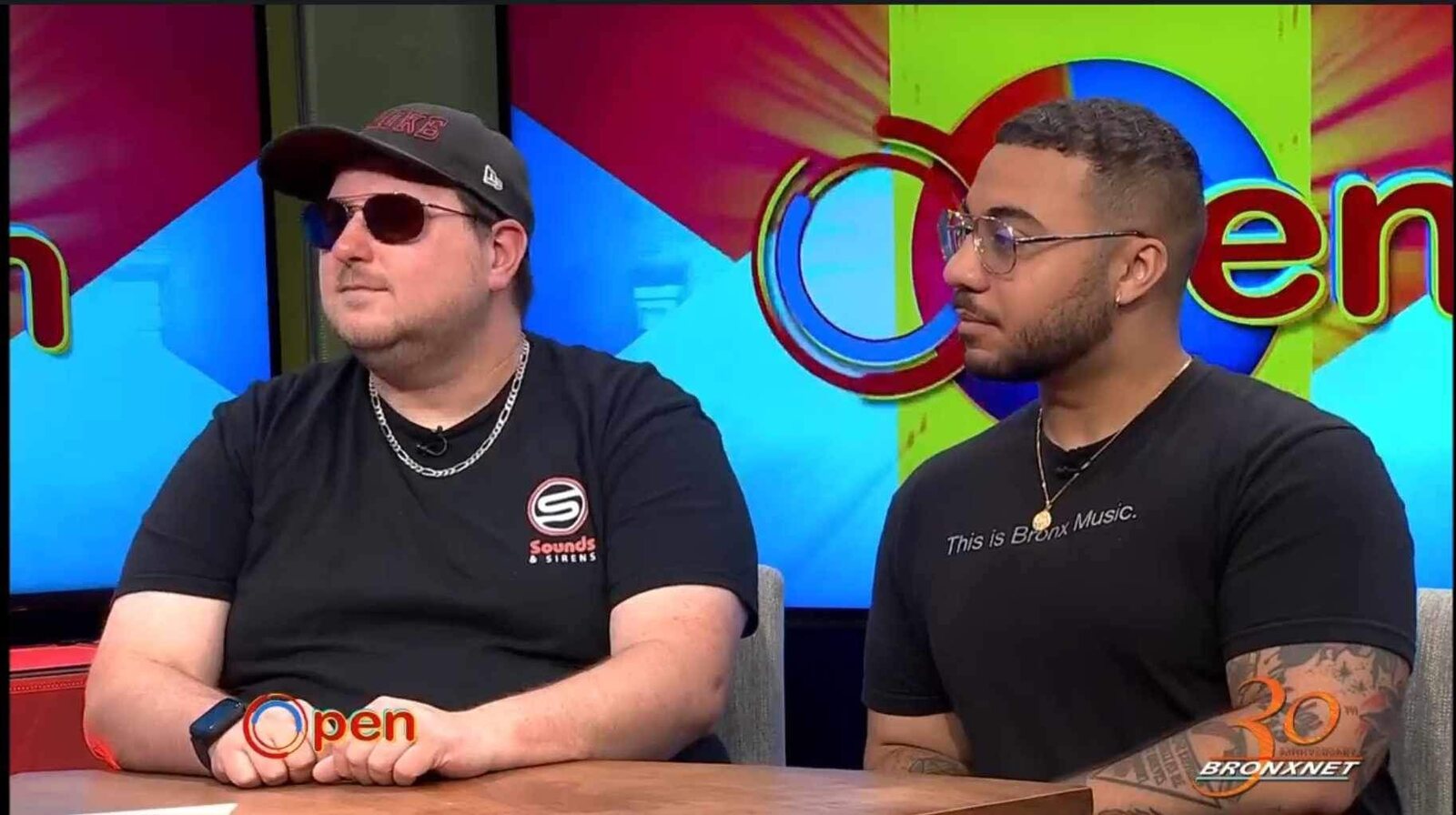 Mike Nickerson wearing a Sounds & Sirens shirt during a BronxNet interview alongside Fernando Michael.