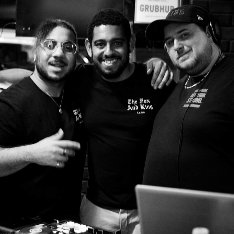 The Fox & King team wearing branded shirts in a DJ booth at a Bronx nightlife event.